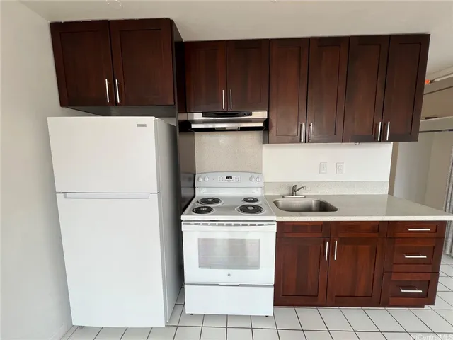 a kitchen with a stove top oven and cabinets