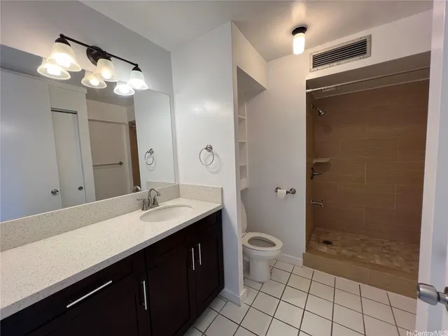 a bathroom with a sink a toilet a mirror and shower