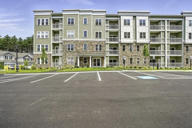 a front view of building with yard and trees