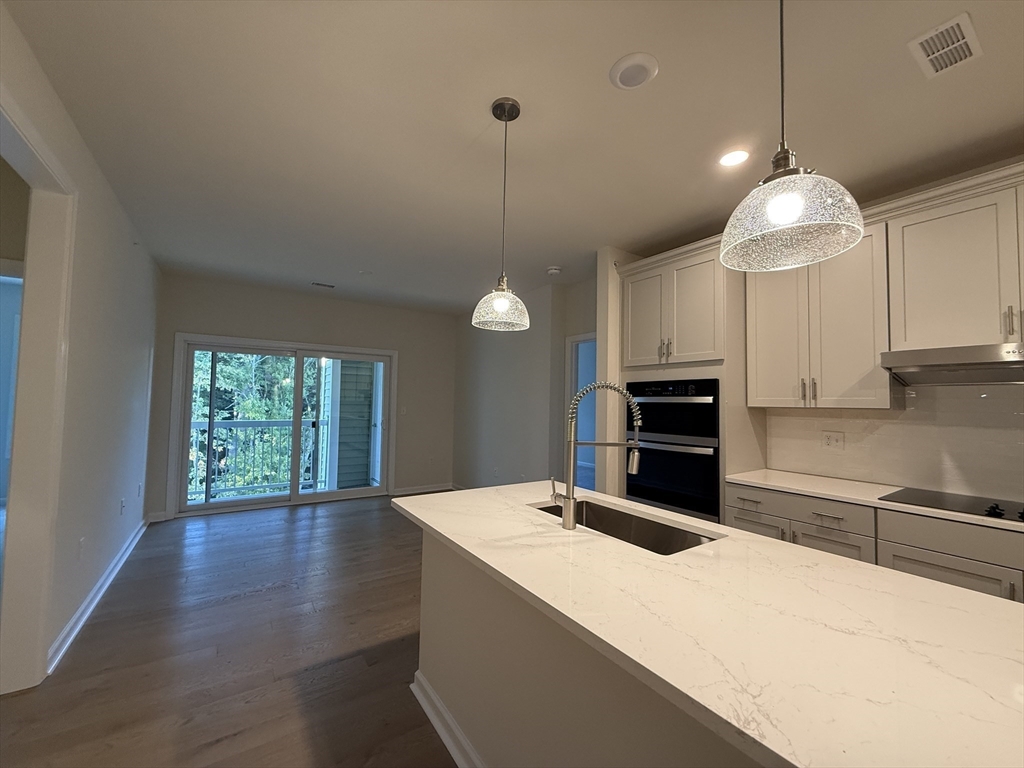 4 Winslow Lane, Unit 1411 North Grafton, MA 01536 - Photo 14 of 36 a kitchen with kitchen island a counter space a sink and appliances