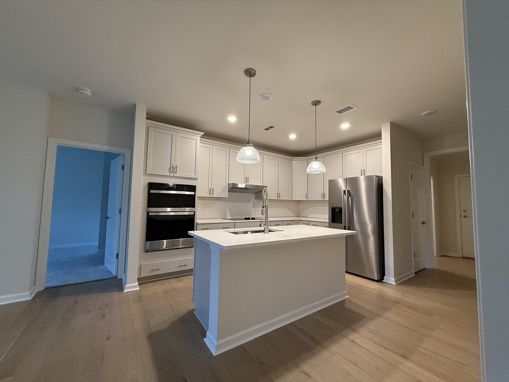 4 Winslow Lane, Unit 1411 North Grafton, MA 01536 - Photo 35 of 36 a kitchen with kitchen island a sink stainless steel appliances and cabinets