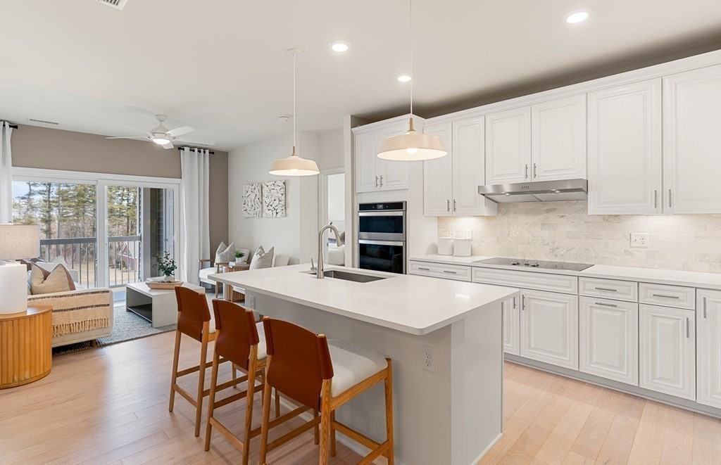 4 Winslow Lane, Unit 1411 North Grafton, MA 01536 - Photo 6 of 36 a kitchen with stainless steel appliances granite countertop a table chairs sink and cabinets