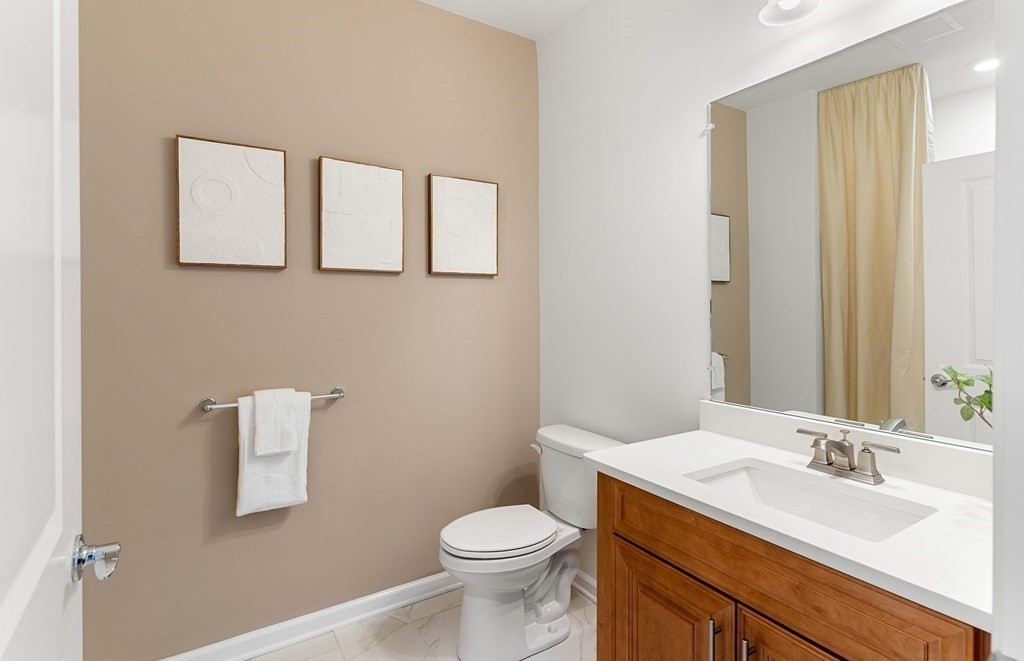 4 Winslow Lane, Unit 1411 North Grafton, MA 01536 - Photo 9 of 36 a bathroom with a toilet a sink and mirror