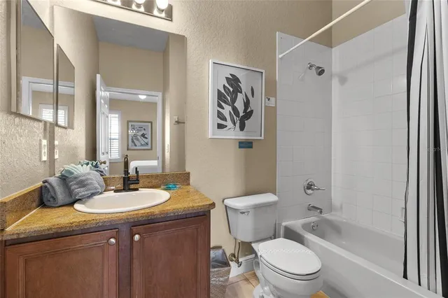 a bathroom with a sink a toilet a mirror a vanity a bath tub and shower