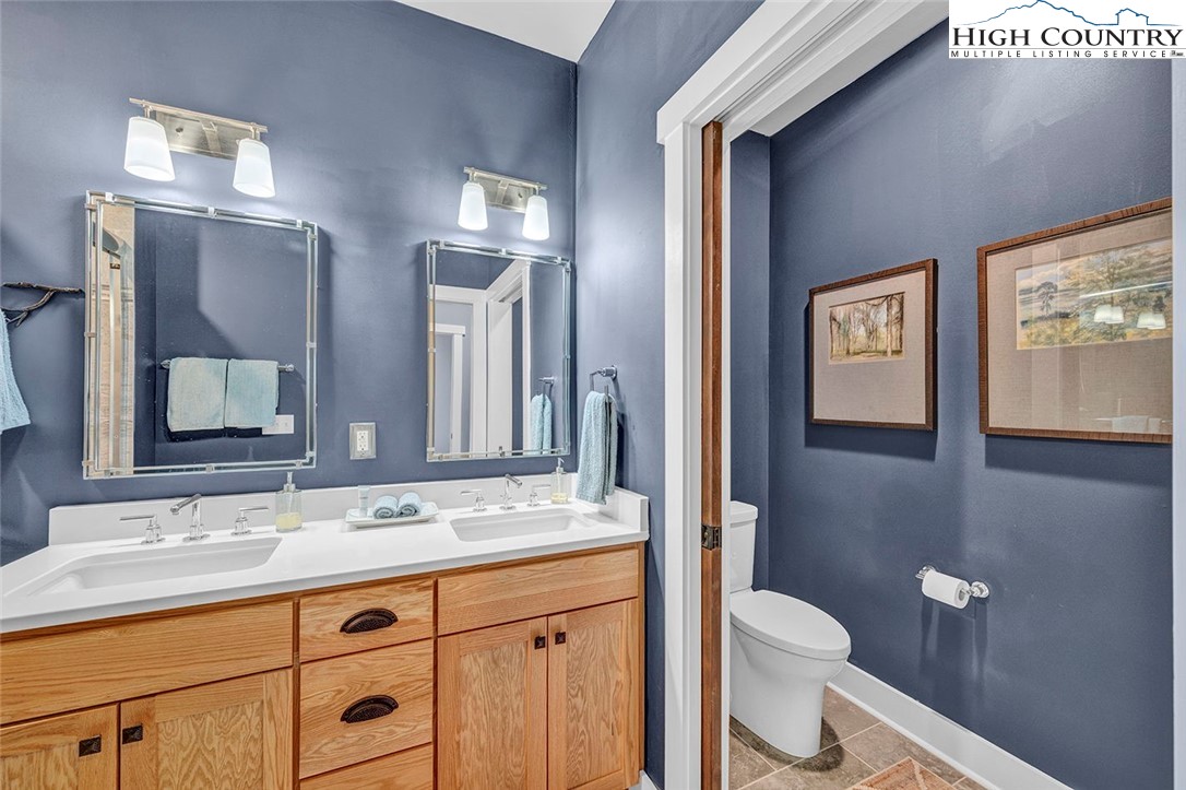 188 Ramblestone Terrace, Unit 101 Boone, NC 28607 - Photo 24 of 48 a bathroom with a granite countertop toilet sink and mirror
