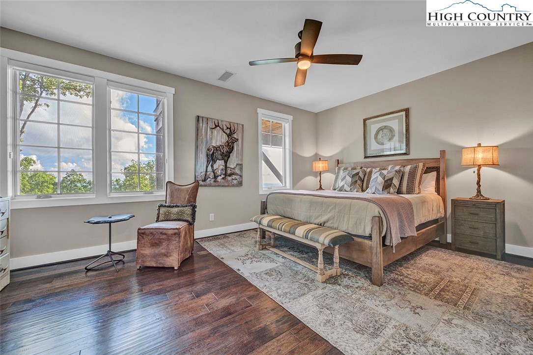 188 Ramblestone Terrace, Unit 101 Boone, NC 28607 - Photo 26 of 48 a spacious bedroom with a large bed a chandelier and windows