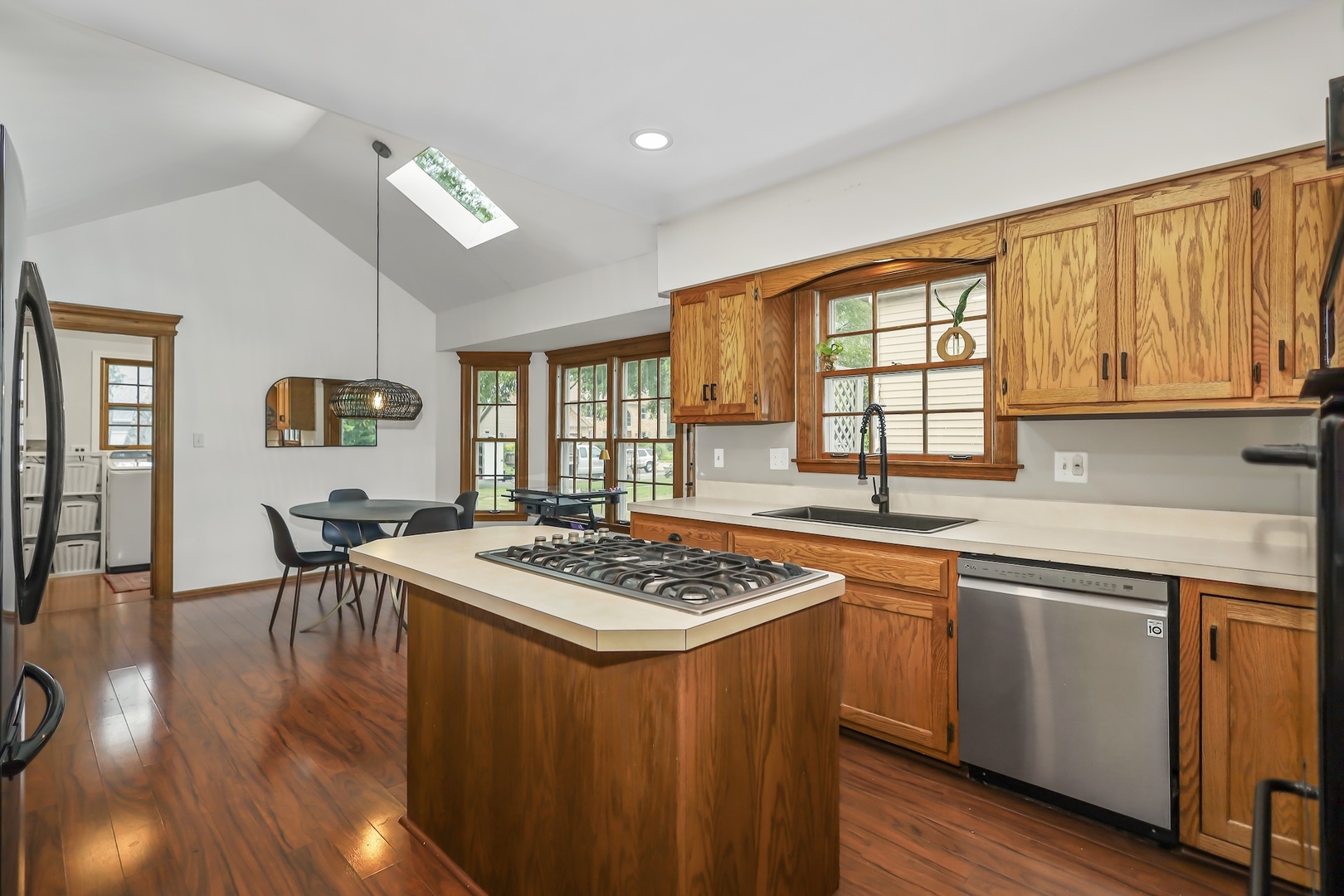 1091 Danforth Drive Batavia, IL 60510 - Photo 12 of 40 a kitchen with a stove a sink dishwasher white refrigerator a dining table and chairs with wooden floor