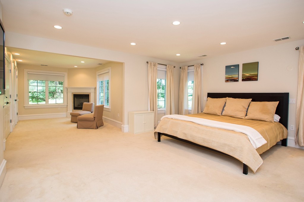 41 Cutler Lane Brookline, MA 02467 - Photo 9 of 12 a spacious bedroom with a large bed and a chandelier