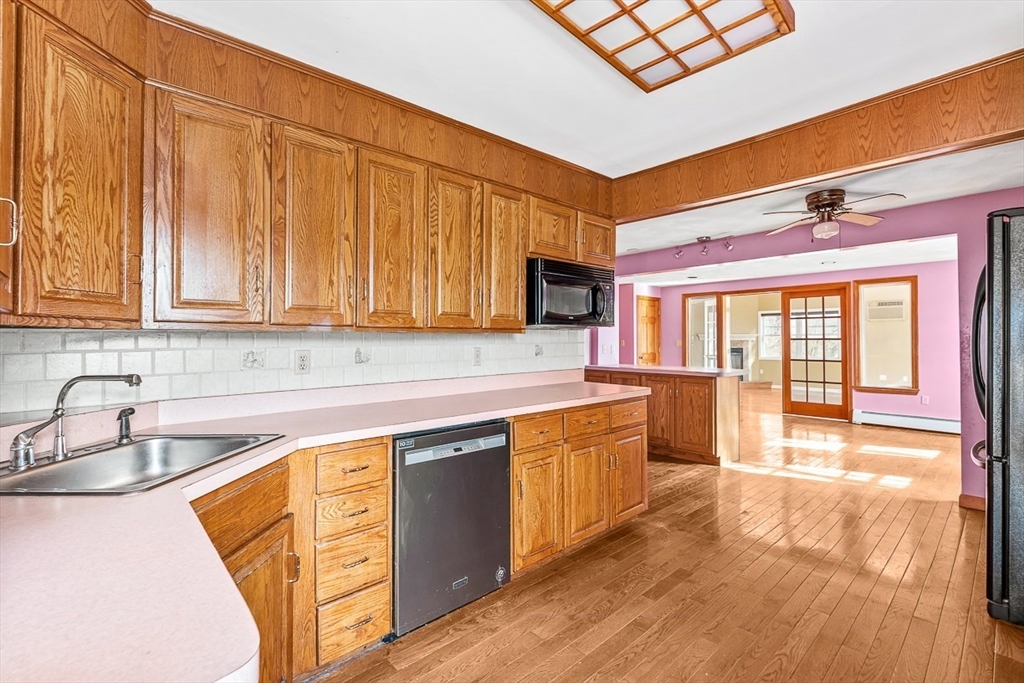 15 Tremont Street Stoneham, MA 02180 - Photo 15 of 38 a kitchen with stainless steel appliances granite countertop a sink and cabinets with wooden floor