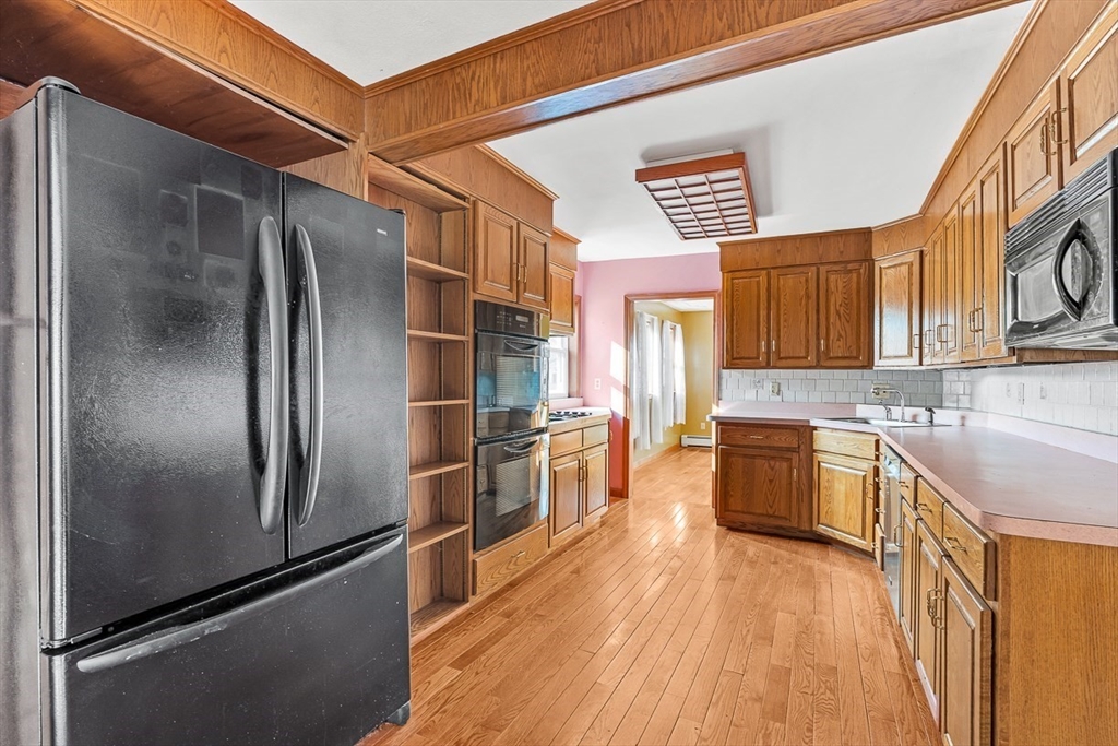 15 Tremont Street Stoneham, MA 02180 - Photo 17 of 38 a kitchen with stainless steel appliances granite countertop a refrigerator a stove and a sink
