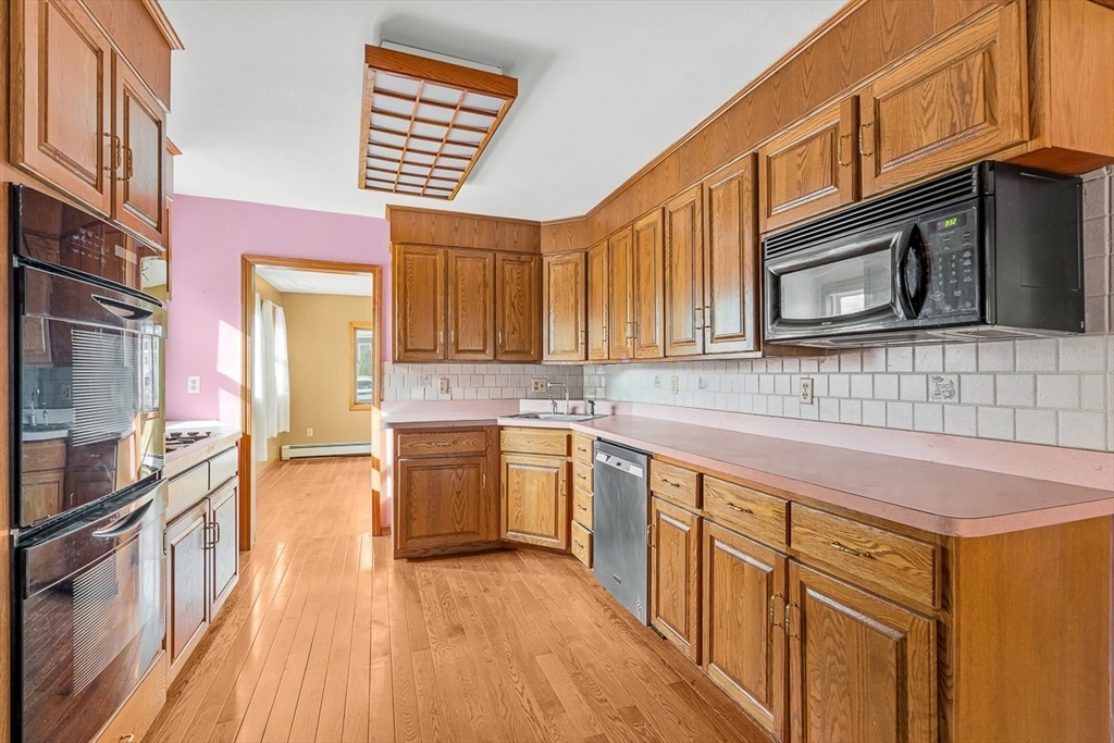 15 Tremont Street Stoneham, MA 02180 - Photo 18 of 38 a kitchen with stainless steel appliances granite countertop a stove and cabinets