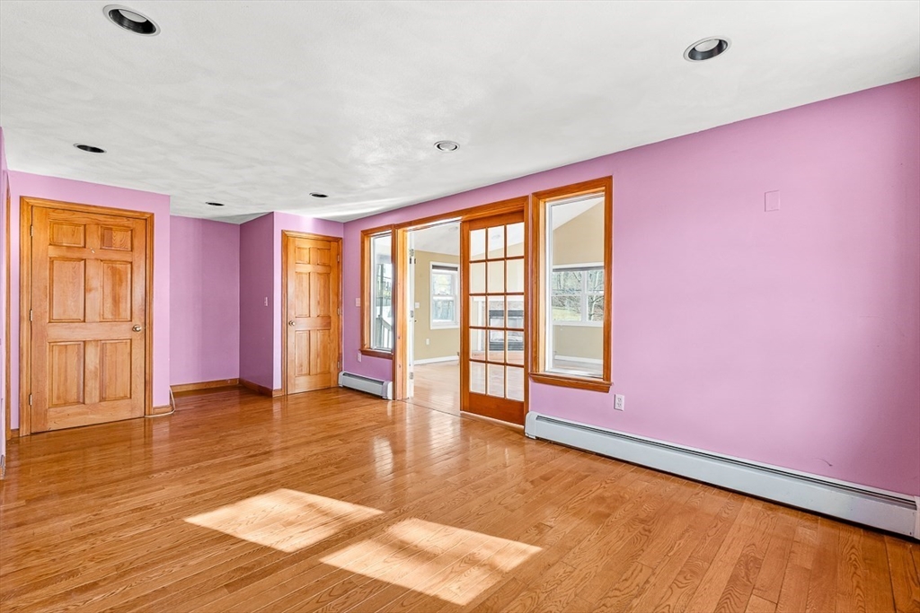 15 Tremont Street Stoneham, MA 02180 - Photo 20 of 38 a view of an empty room with window a ceiling fan and wooden floor