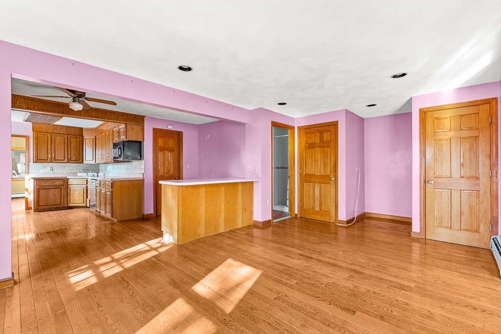15 Tremont Street Stoneham, MA 02180 - Photo 21 of 38 a view of an empty room with wooden floor and a kitchen