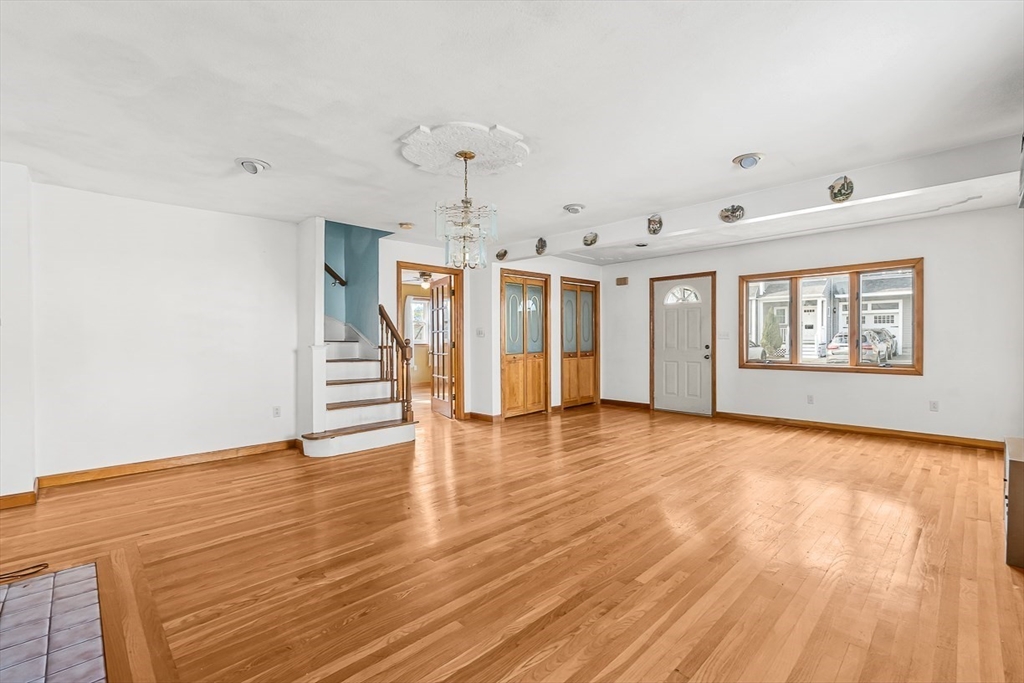 15 Tremont Street Stoneham, MA 02180 - Photo 5 of 38 a view of an empty room with wooden floor and a window