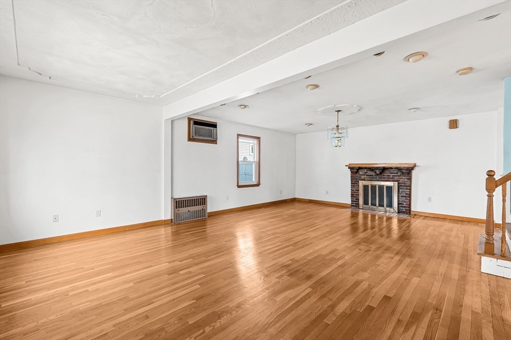 15 Tremont Street Stoneham, MA 02180 - Photo 8 of 38 a view of a livingroom with wooden floor and a refrigerator