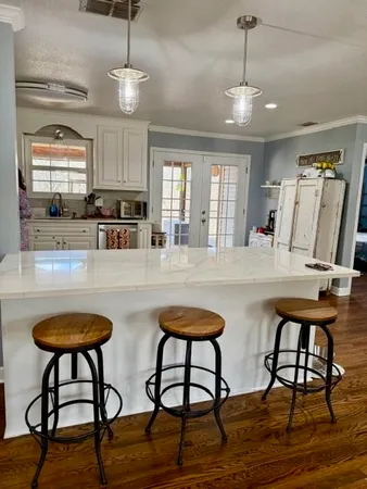 a kitchen with stainless steel appliances granite countertop a dining table chairs and granite counter tops