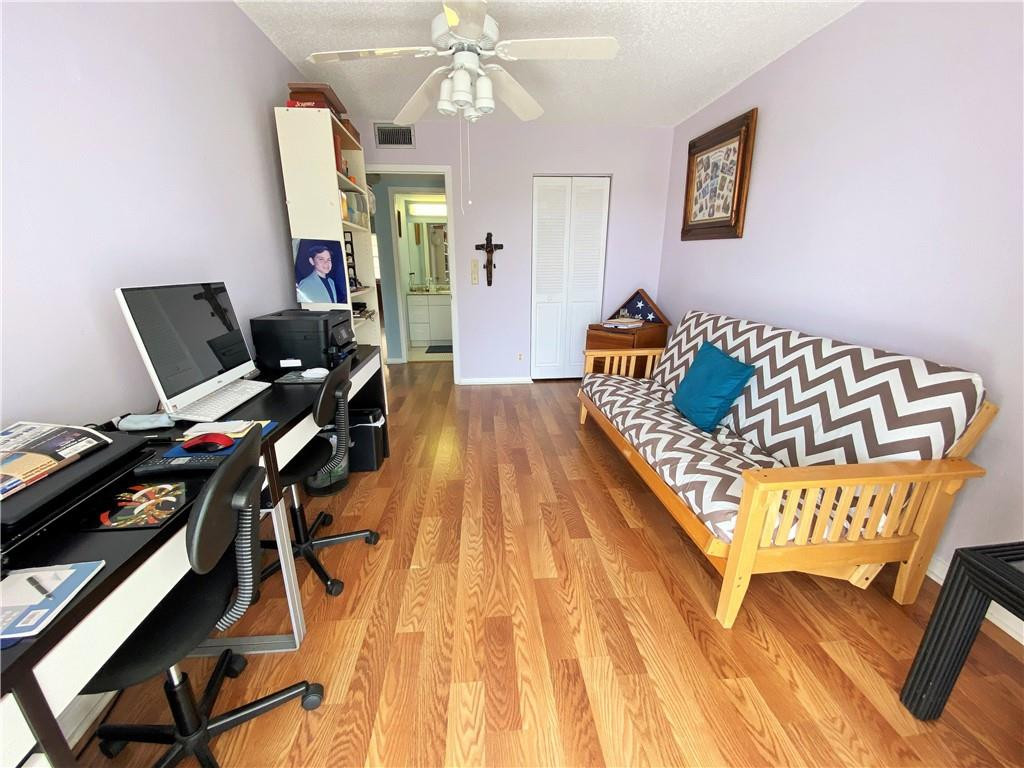 4055 Newcastle A, Unit 4055 Boca Raton, FL 33434 - Photo 11 of 23 a bedroom with a bed and wooden floor