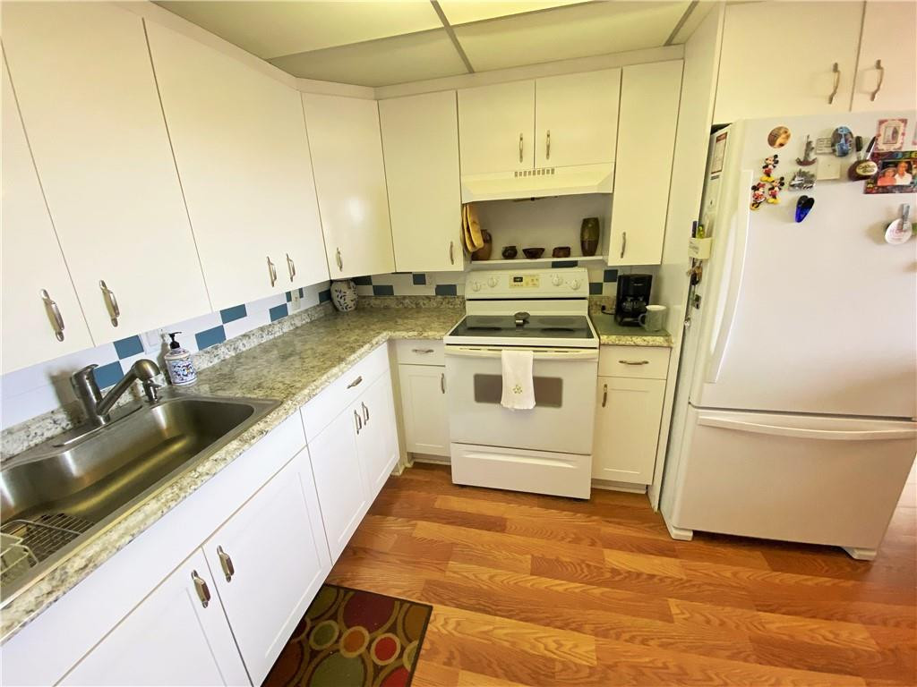 4055 Newcastle A, Unit 4055 Boca Raton, FL 33434 - Photo 17 of 23 a white kitchen with sink a refrigerator and white cabinets