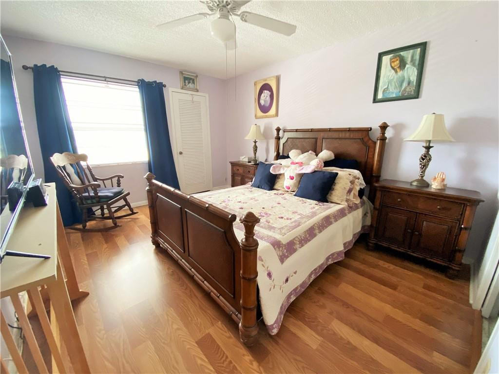 4055 Newcastle A, Unit 4055 Boca Raton, FL 33434 - Photo 6 of 23 a bedroom with a bed and wooden floor