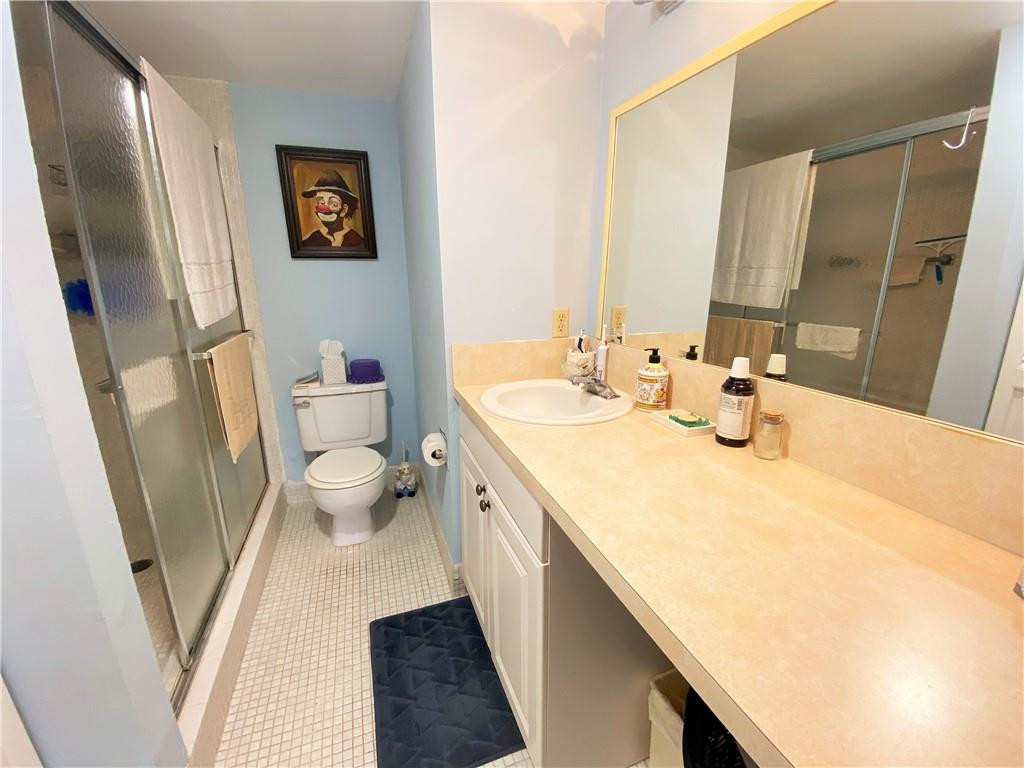 4055 Newcastle A, Unit 4055 Boca Raton, FL 33434 - Photo 8 of 23 a bathroom with a sink and a large mirror