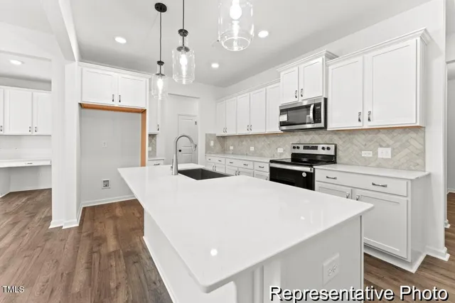 a kitchen with kitchen island a white counter top space cabinets and stainless steel appliances