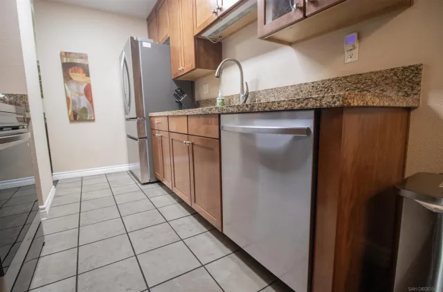 a close view of a refrigerator in kitchen and an empty room