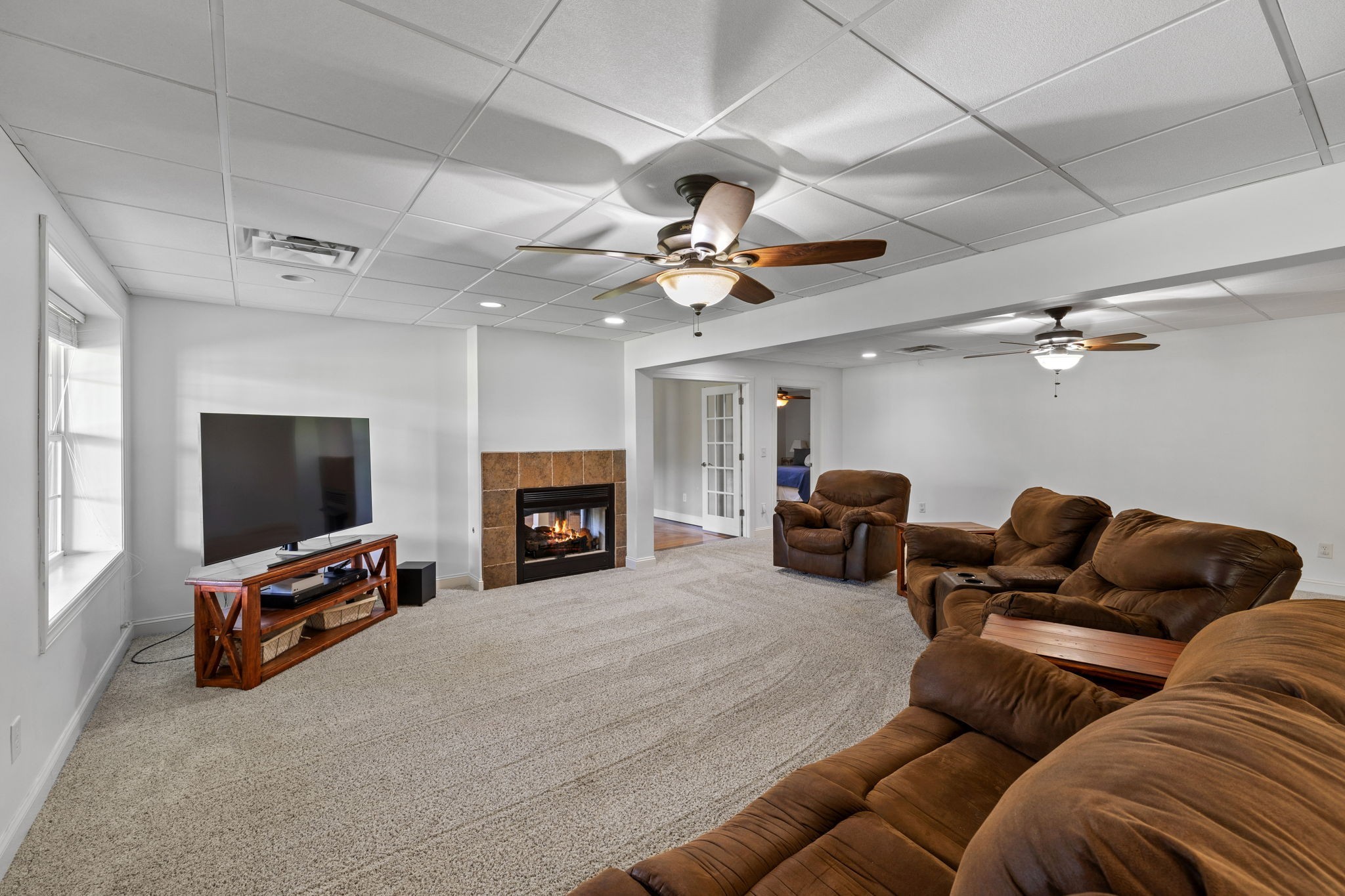 6213 Lampkins Bridge Road College Grove, TN 37046 - Photo 36 of 70 Comfortable seating arrangements are arranged around the fireplace, inviting guest to gather and socialize. Large windows allow natural light to filter in, creating a warm & inviting atmosphere.