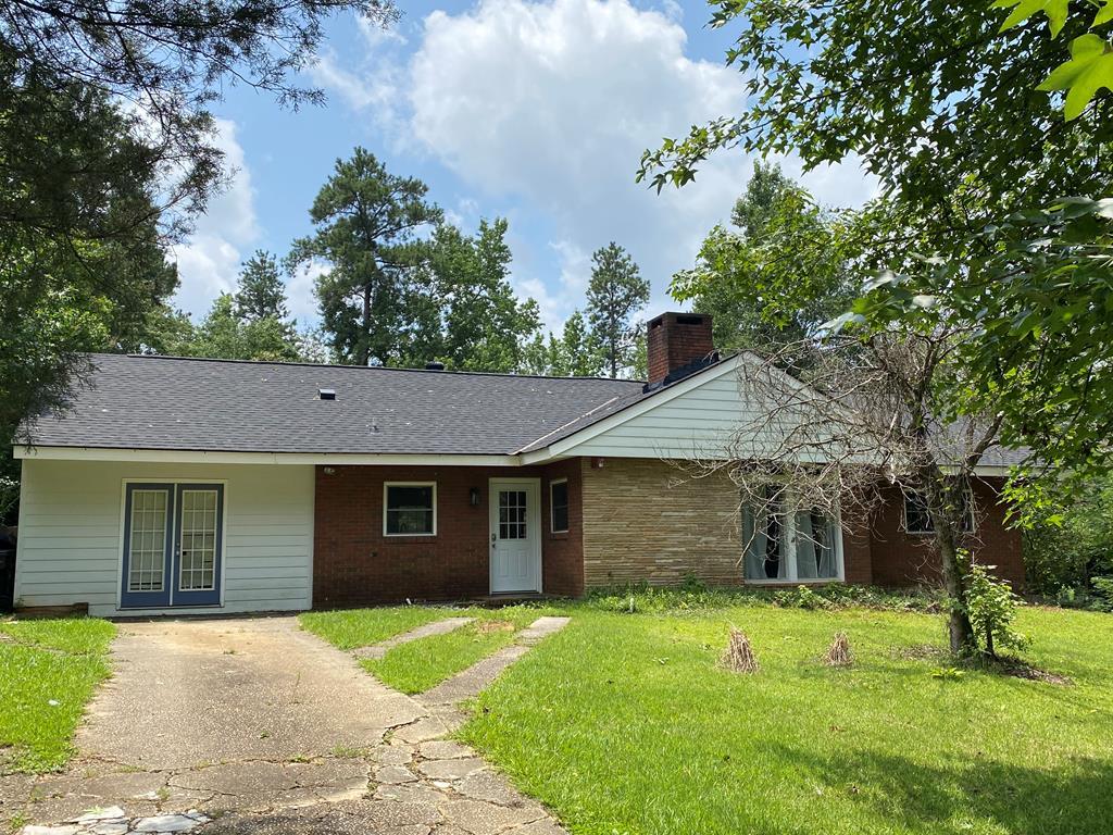 a front view of a house with a garden and yard