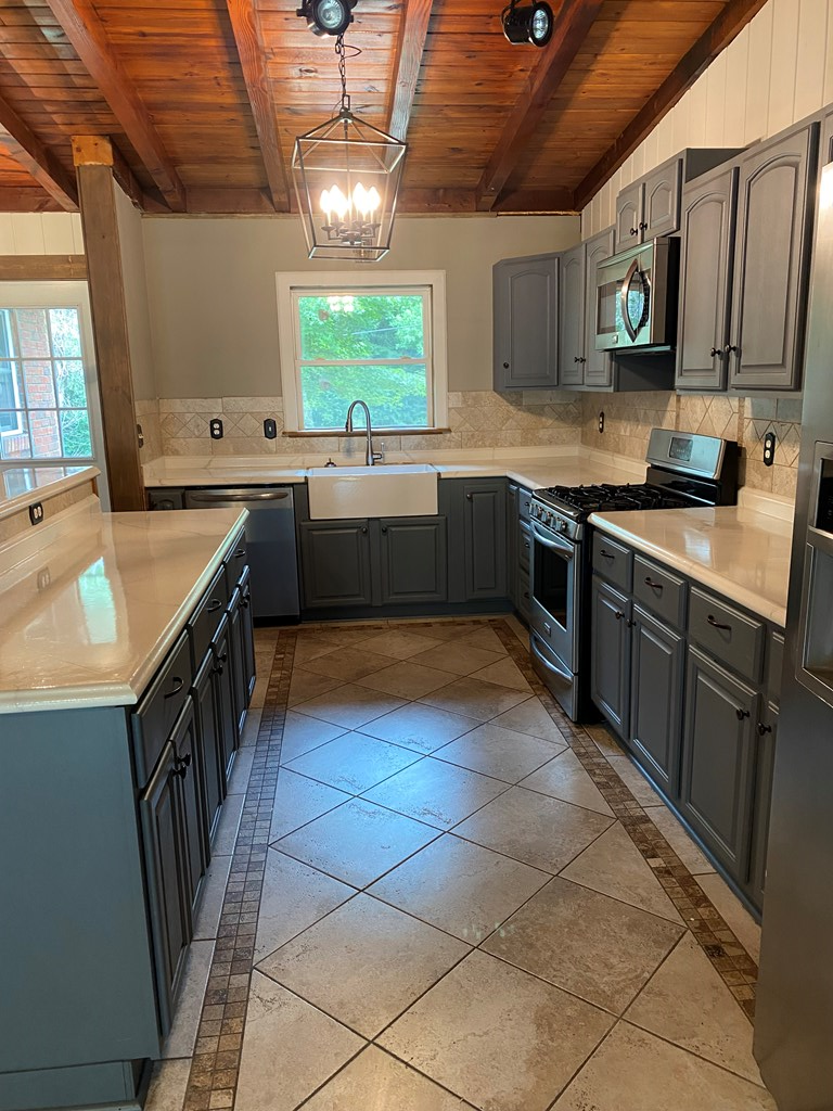 1609 4th Place Phenix City, AL 36869 - Photo 5 of 14 a kitchen with stainless steel appliances granite countertop a sink a stove a counter top space cabinets and a window