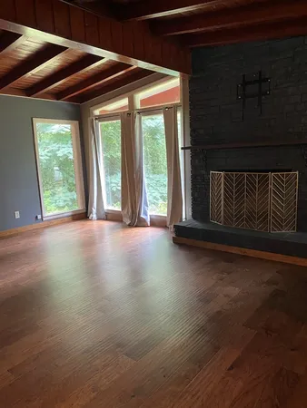a view of a room with wooden floor and windows