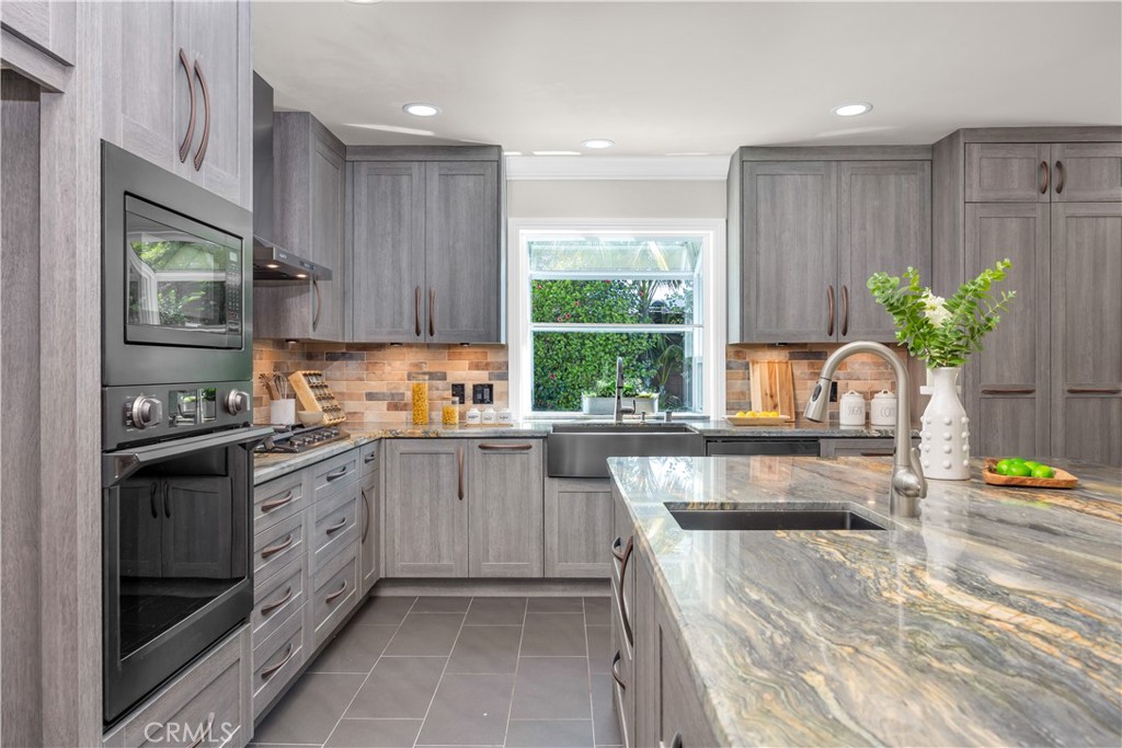 1391 Deborah Drive North Tustin, CA 92705 - Photo 3 of 56 a kitchen with kitchen island granite countertop a sink stainless steel appliances and cabinets