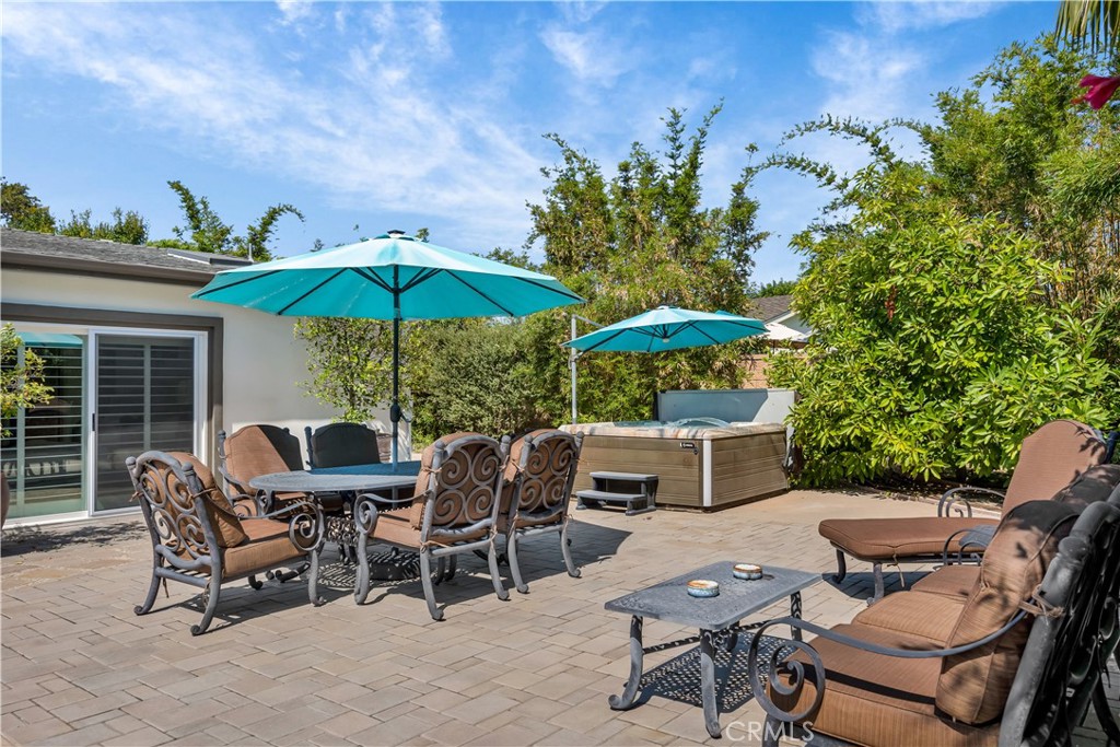 1391 Deborah Drive North Tustin, CA 92705 - Photo 36 of 56 a view of a patio with a dining table and chairs under an umbrella with a barbeque