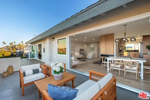 a living room with furniture kitchen view and a large window