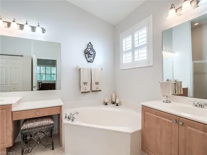 a bathroom with a sink a tub and a mirror