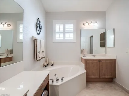 a bathroom with a tub sink and mirror