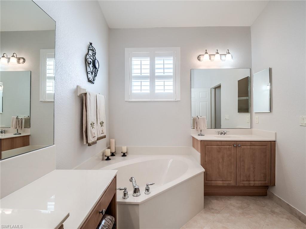 9460 Sun River Way Estero, FL 33928 - Photo 17 of 41 a bathroom with a tub sink and mirror
