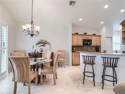 a view of a dining room with furniture a chandelier and wooden floor
