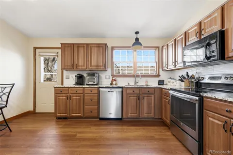 a kitchen with stainless steel appliances granite countertop a stove sink and cabinets