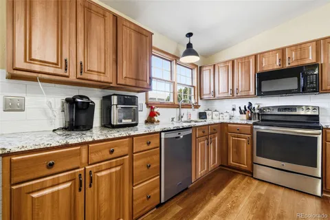 a kitchen with granite countertop a sink and steel appliances
