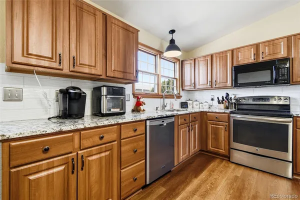 a kitchen with granite countertop a sink and steel appliances
