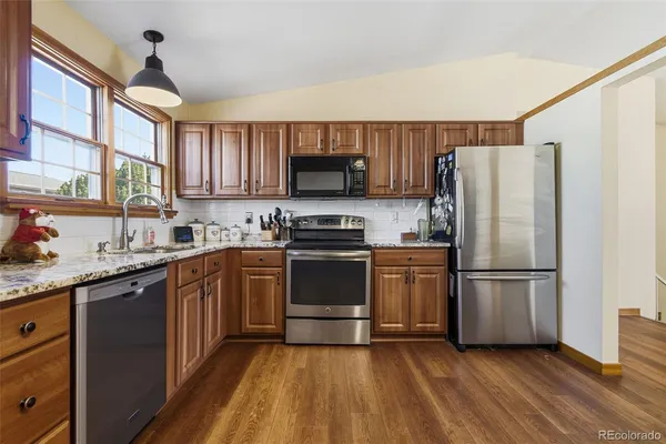a kitchen with a refrigerator stove top oven and sink