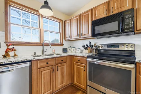 a kitchen with granite countertop cabinets stainless steel appliances and a sink