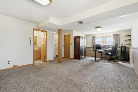 a view of a workspace with furniture and a window