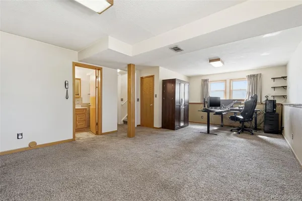 a view of a workspace with furniture and a window