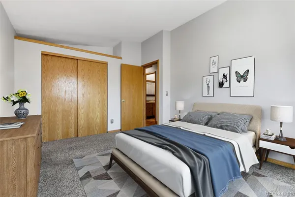 a bedroom with a bed and a painting on the wall