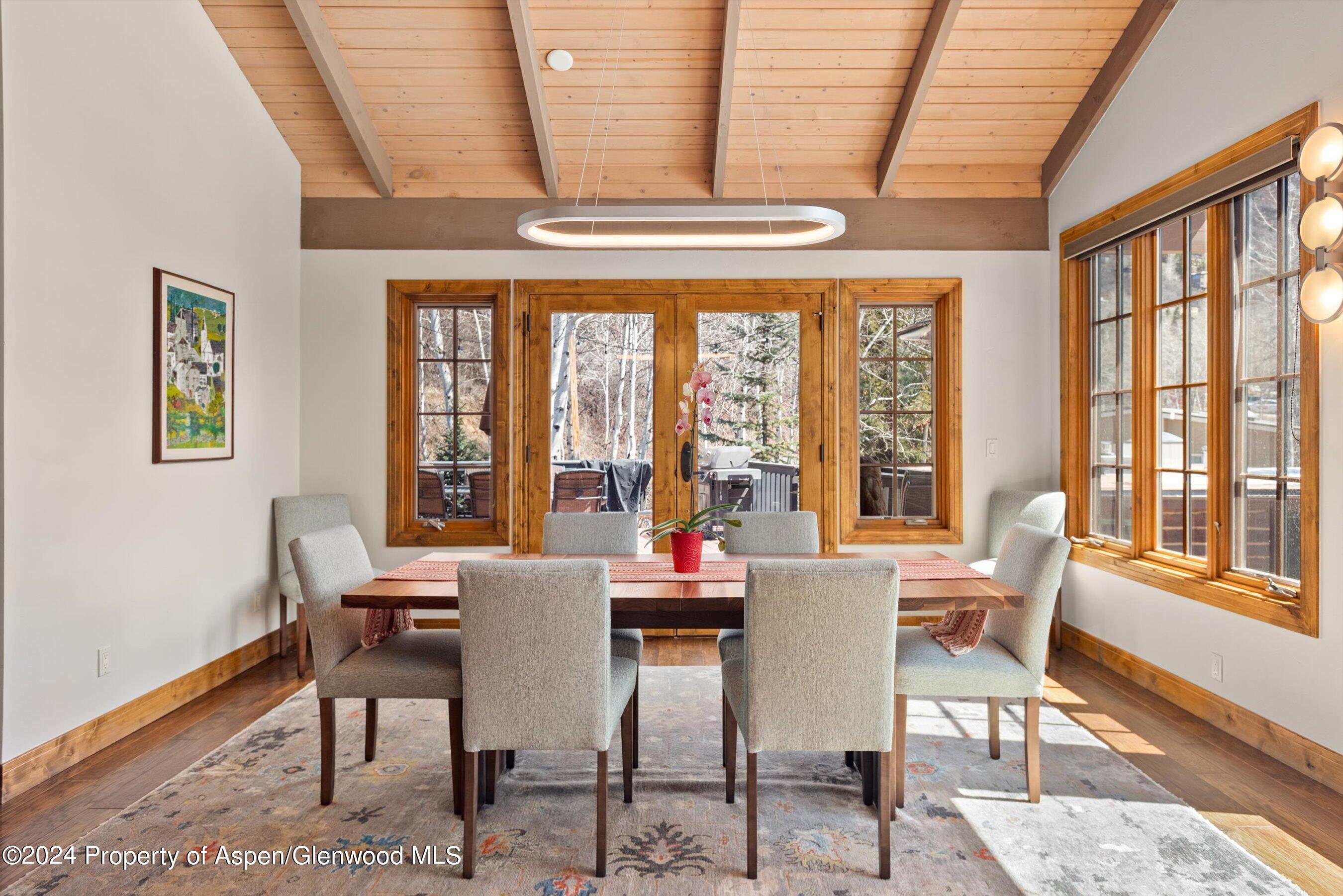 64 Eastwood Road Aspen, CO 81611 - Photo 4 of 24 a view of a dining room with furniture large windows and wooden floor