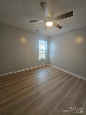 a view of an empty room and window and wooden floor