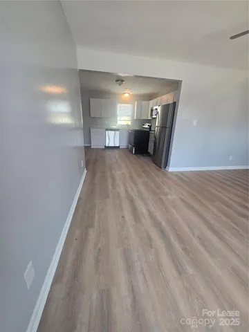 a view of empty room with wooden floor