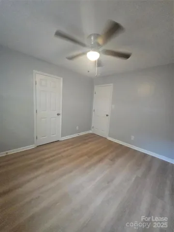 a view of an empty room with a chandelier fan