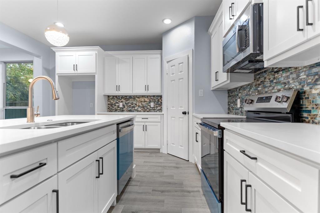 a kitchen with a sink stove and cabinets